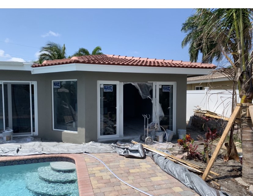 Completed room addition with tile roof and pool view - home extension Naples FL